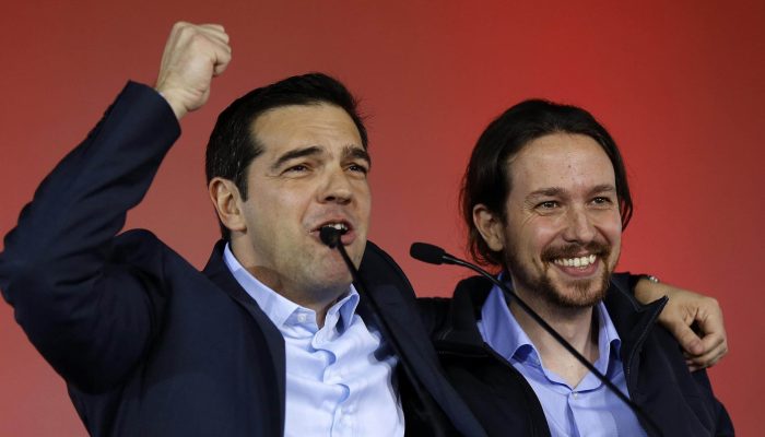 Greek head of Syriza party, Tsipras addresses supporters as Podemos party Secretary General Iglesias smiles during a campaign rally in central Athen