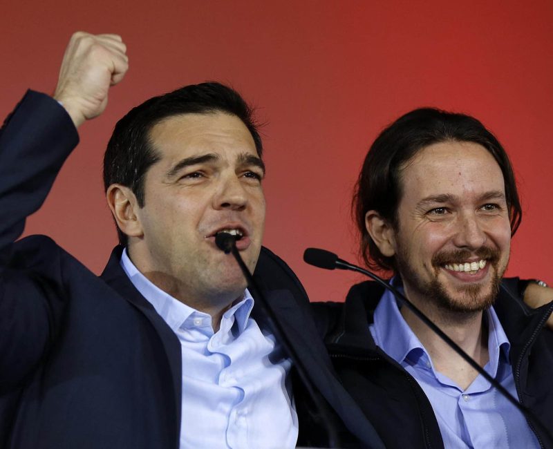 Greek head of Syriza party, Tsipras addresses supporters as Podemos party Secretary General Iglesias smiles during a campaign rally in central Athen