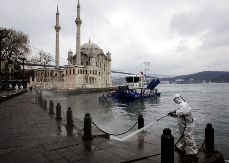 A worker sprays disinfectant outside Ortakoy Mosque, to prevent the spread of coronavirus disease (COVID-19), in Istanbul, Turkey, March 23, 2020. REUTERS/Umit Bektas - RC2MPF90KH23