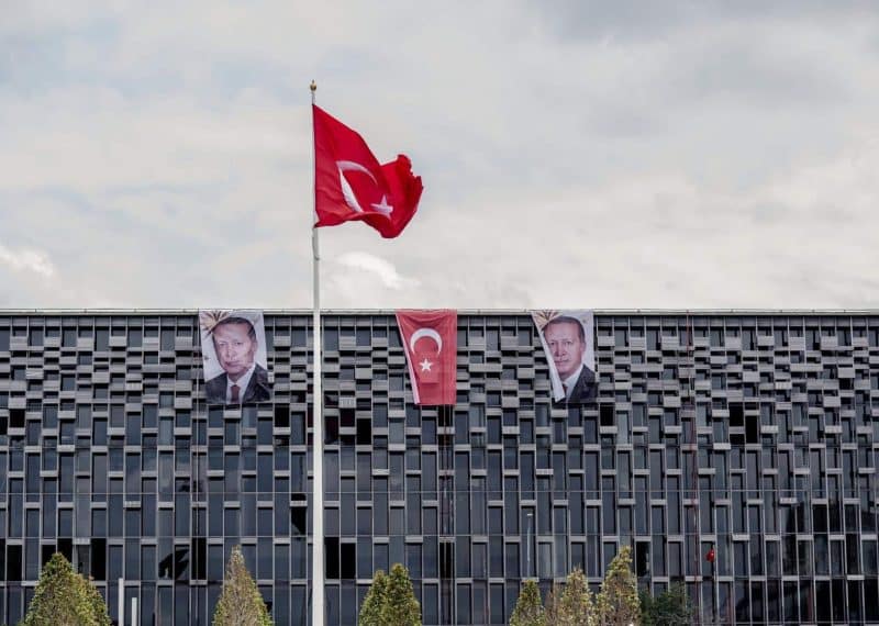 Banners with photographs of Recep Tayyip Erdogan, Turkey's president, hang from the roof of a commercial building either side of a Turkish national flag in Istanbul, Turkey, on Monday, July 18, 2016. Tourism is an essential source of foreign currency to finance Turkey's current-account deficit and employs 8 percent of the nation's workforce. Photographer: Ismail Ferdous/Bloomberg via Getty Images