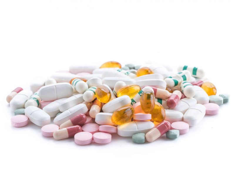 packings of pills and capsules of medicines on white background